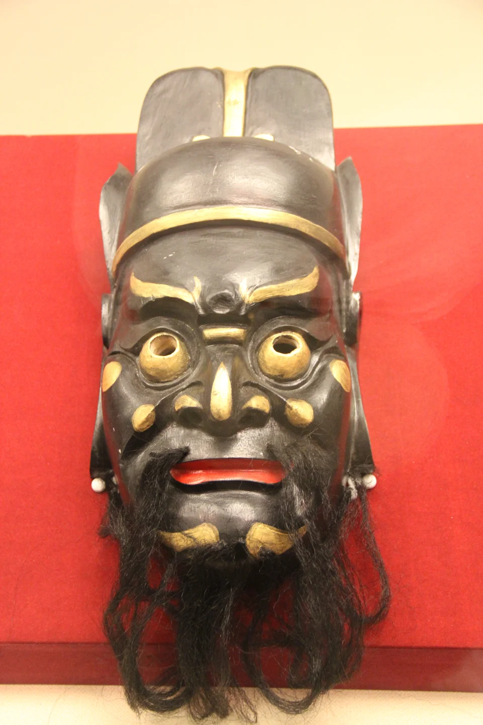成都金沙遺址博物館特展中的儺戲面具，黑底金色眉目，配黑鬚